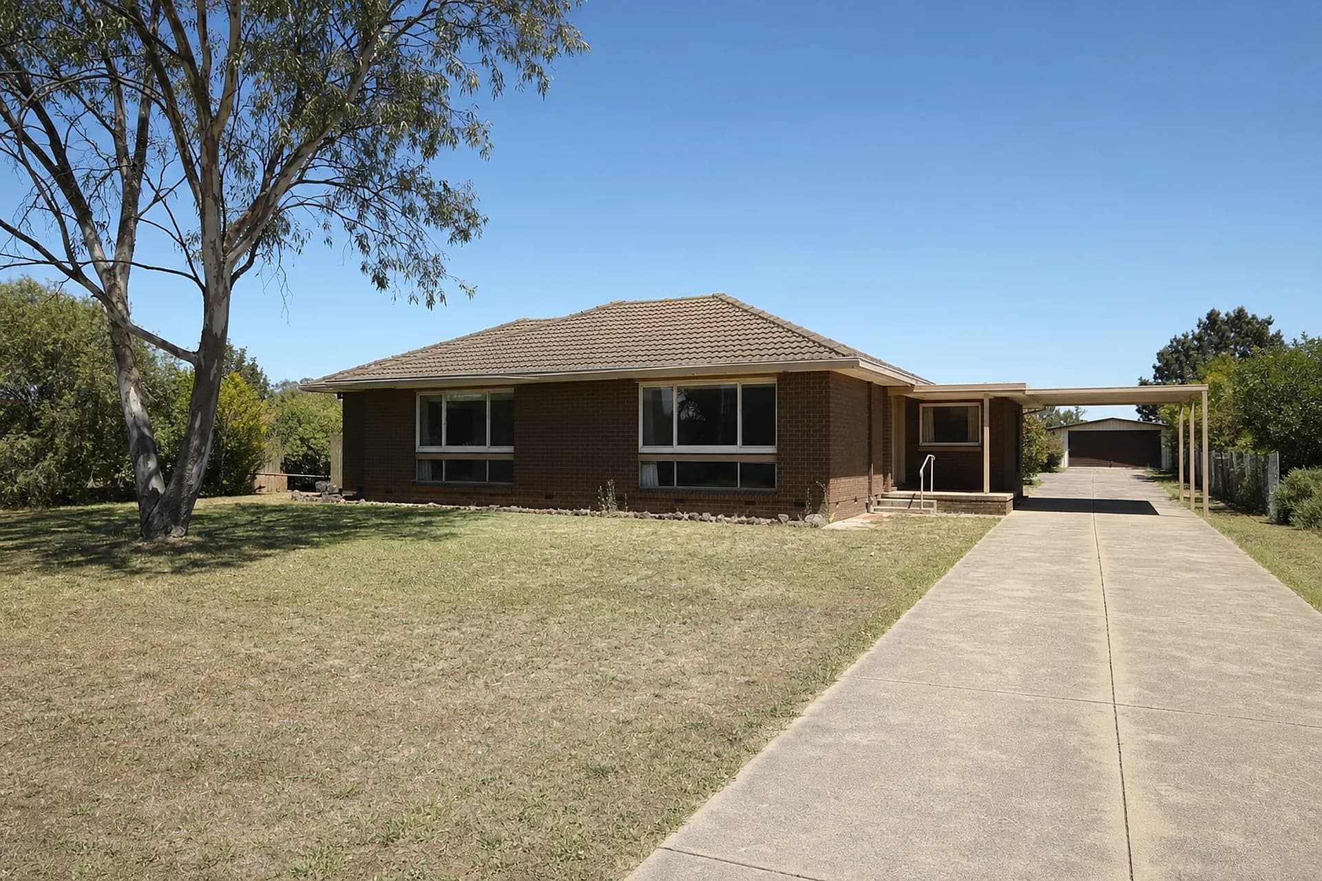 An empty 1970s brick and tile house in Gosnells on a large block, with a long driveway to a rear dwelling