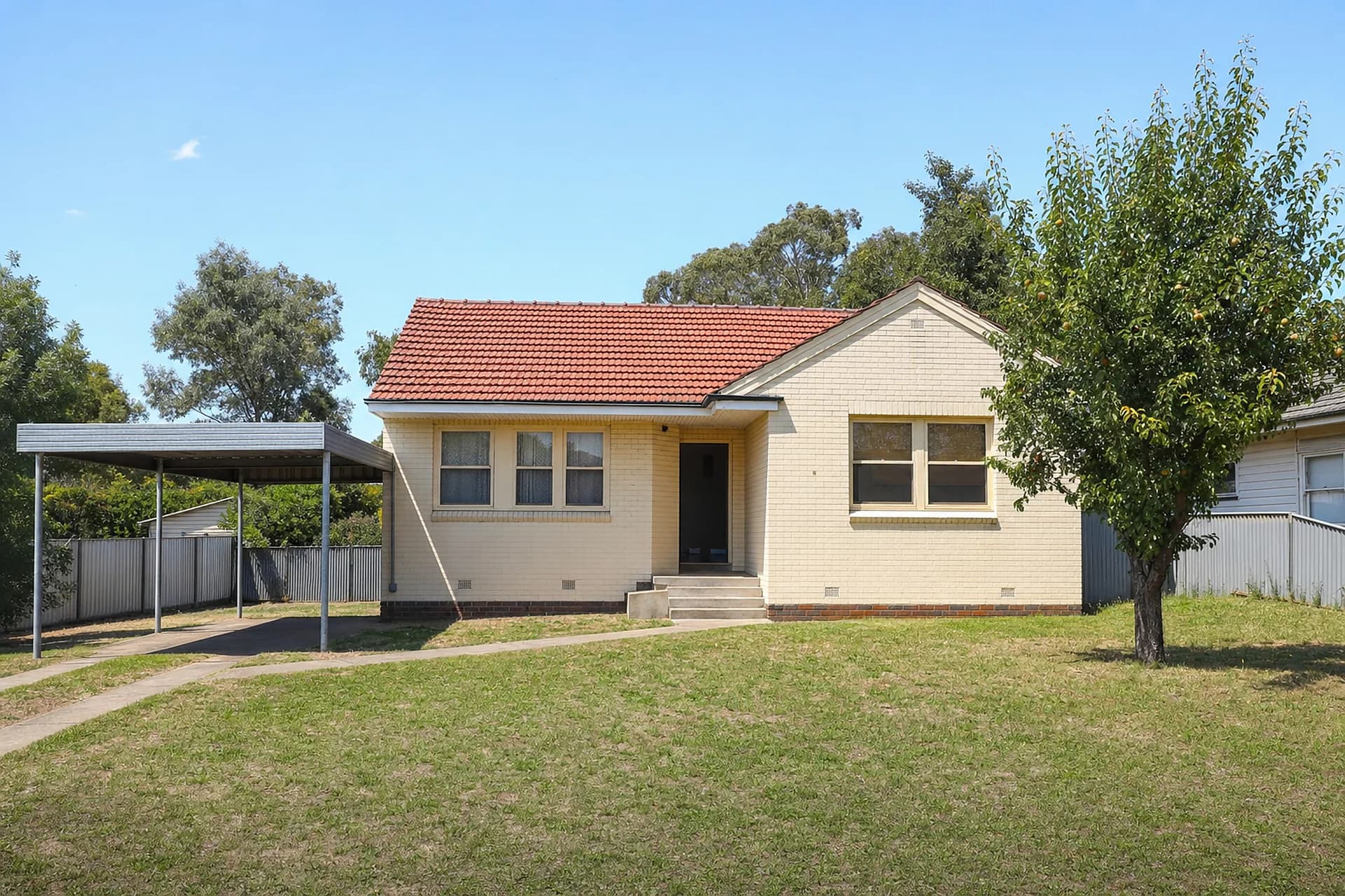 An empty 1950s double brick cottage in Kwinana with a steel carport, the older rental stock of Medina and Orelia