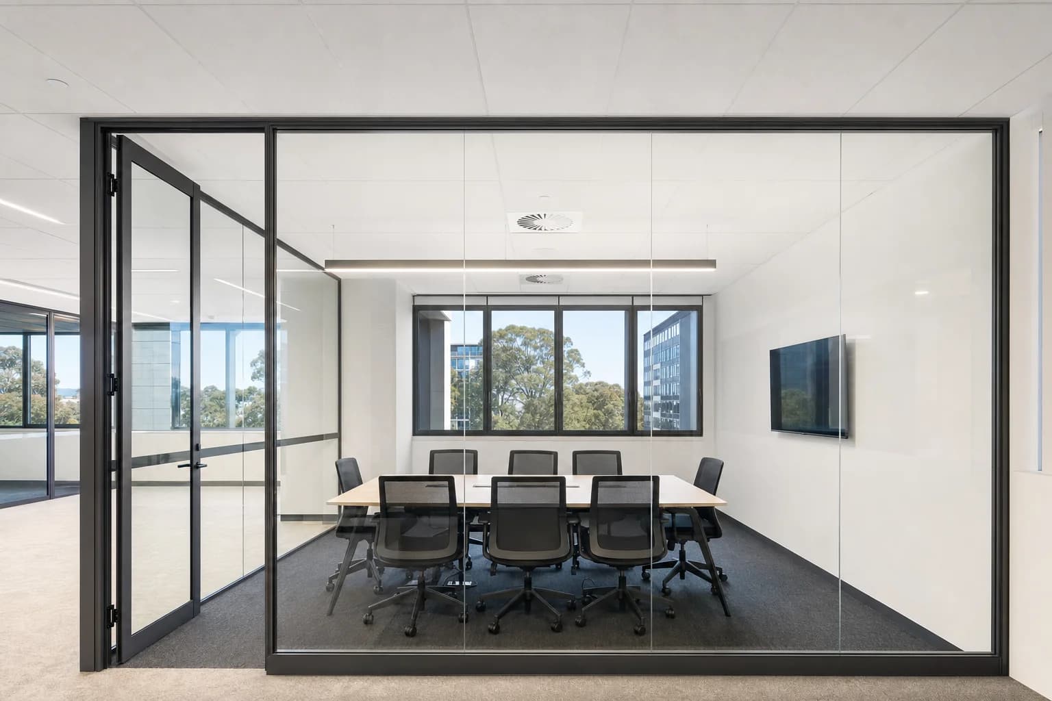 A clean glass partition wall in an empty office meeting room